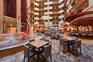 Un hall d’hôtel à plusieurs niveaux, doté d’une fontaine centrale, de coins salon et d’un bar.