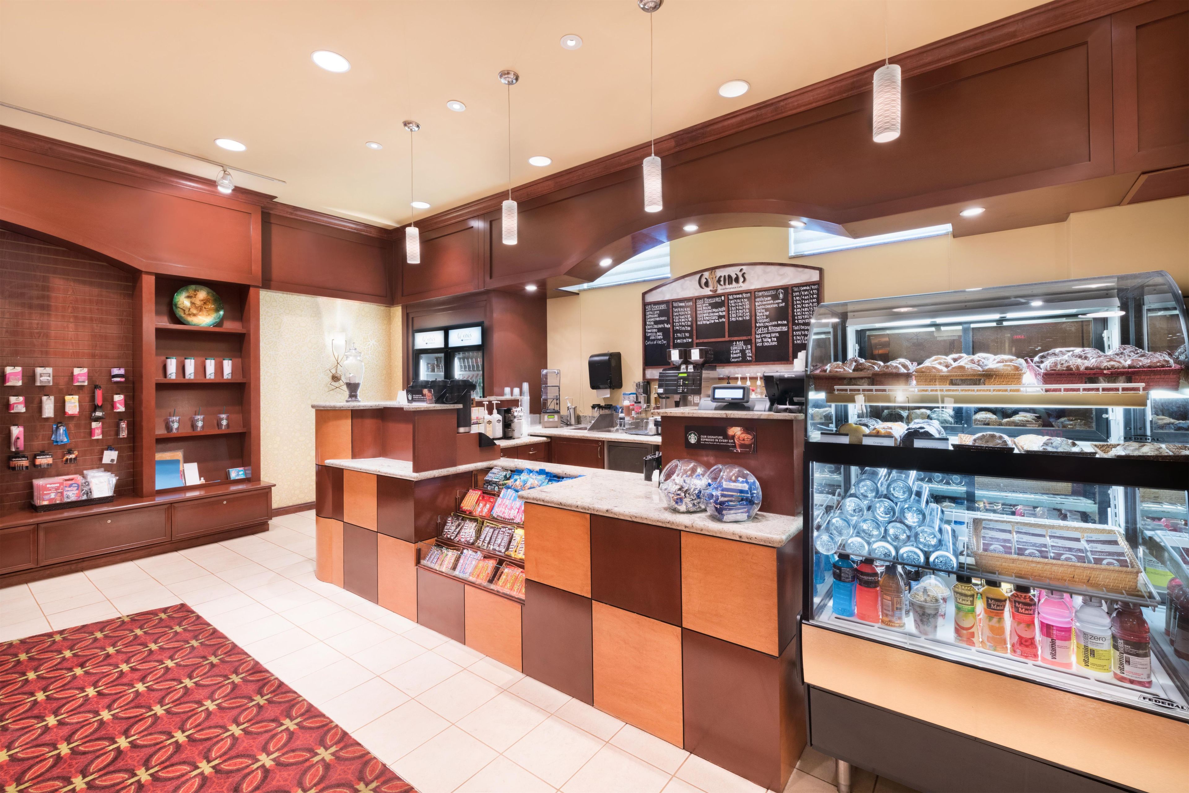 A coffee shop interior with a counter, display cases, and a menu board.