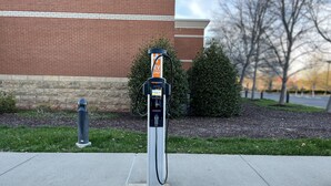 An electric vehicle charging station in front of a brick building. - Embassy Suites by Hilton Nashville SE Murfreesboro (Murfreesboro)