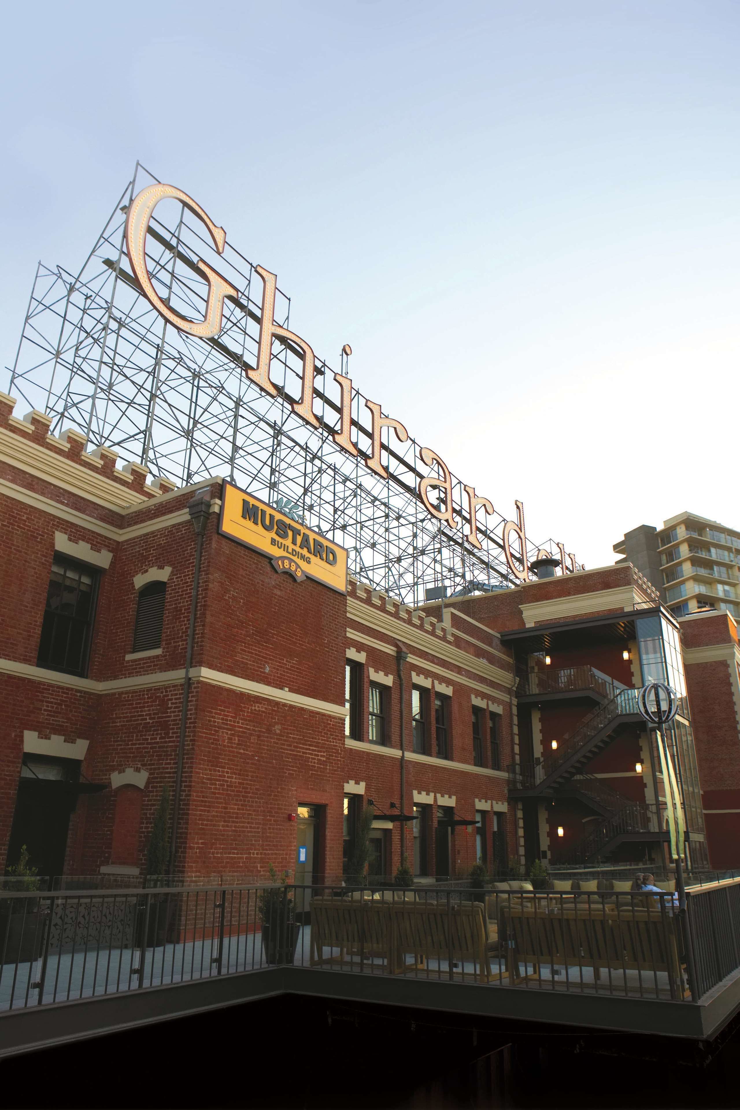A historic building with a large sign reading "Gibson" and "Mustard Building 1869".