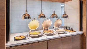 Un buffet avec plusieurs présentoirs de nourriture et des lampes suspendues décoratives.