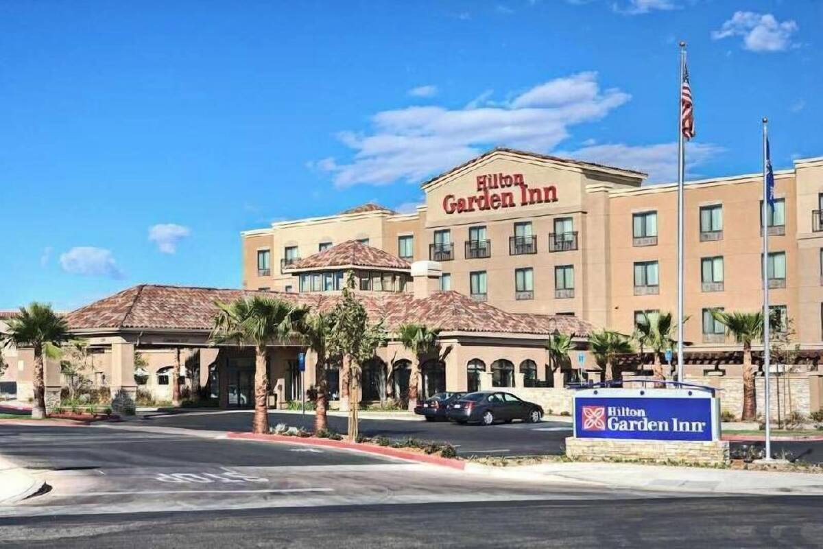 A Hilton Garden Inn with a tiled roof, multiple balconies, and a signboard.