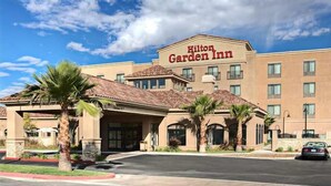 A Hilton Garden Inn with a modern design, featuring a prominent entrance, multiple windows, and palm trees in the landscaping. - Hilton Garden Inn Palmdale (Palmdale)