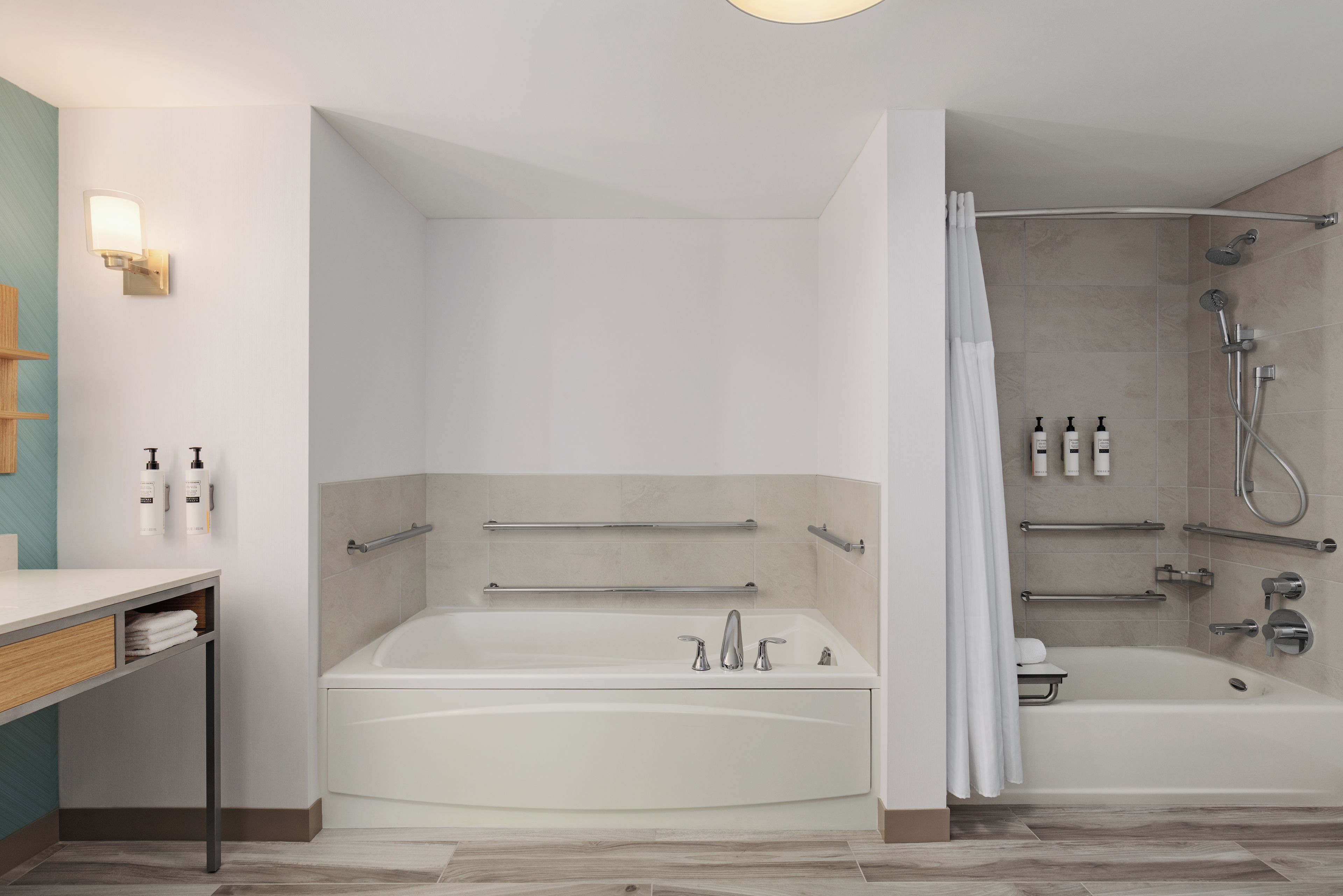 A modern bathroom with a bathtub, shower, and vanity.