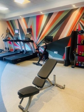 A gym with treadmills, a bench, and a colorful wall. - Hilton Garden Inn Palmdale (Palmdale)