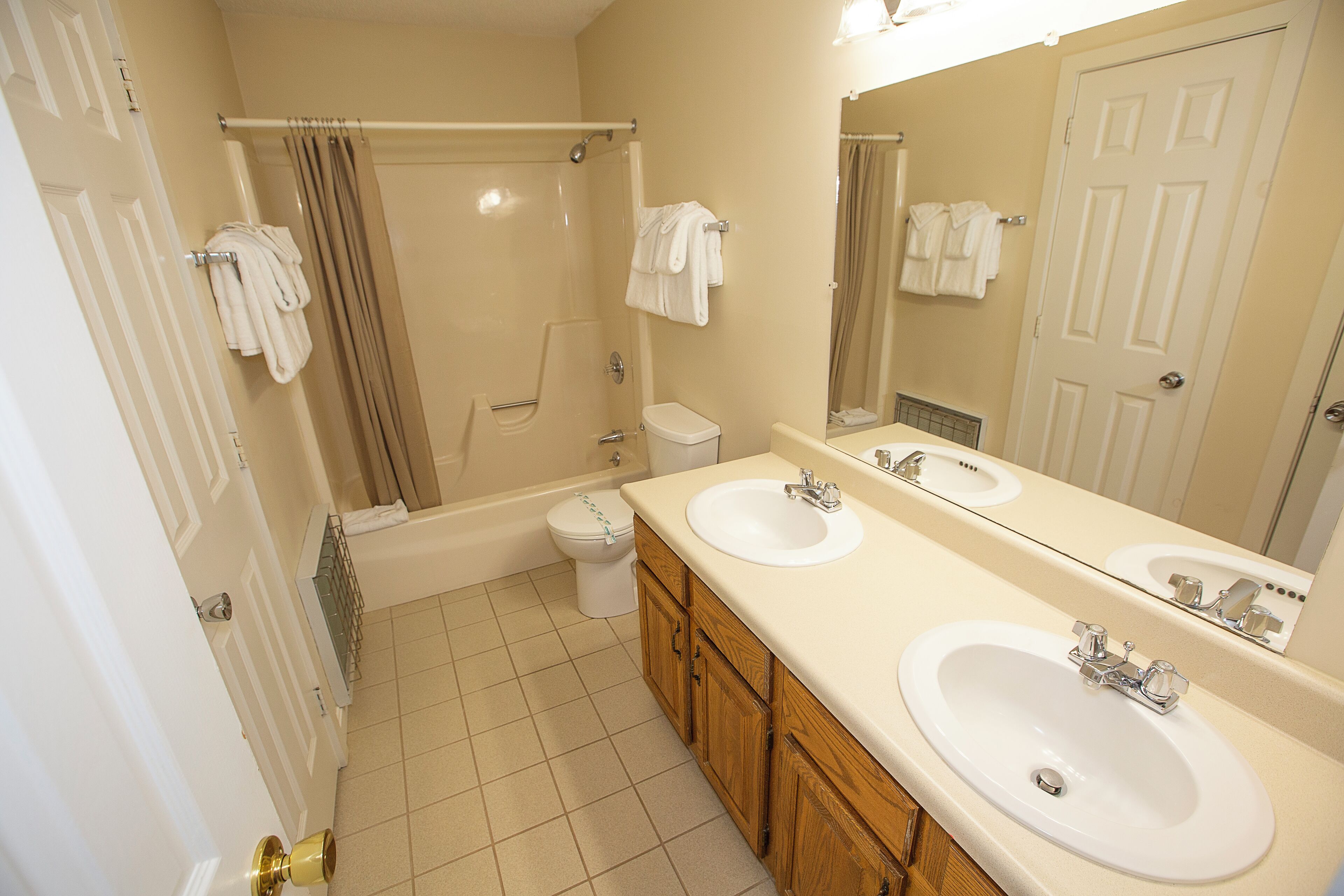 A bathroom with two sinks, a bathtub, a toilet, and a shower.