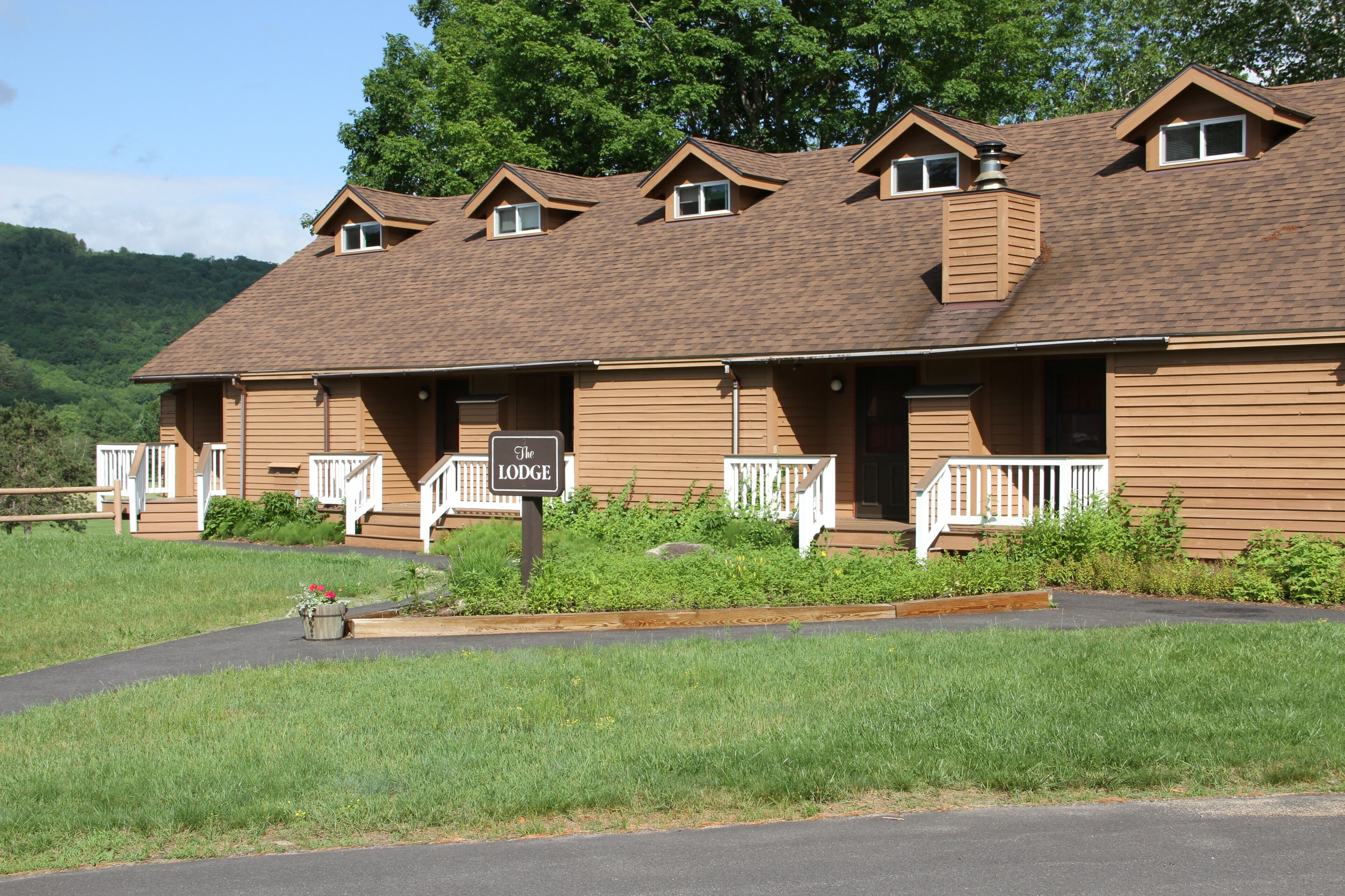 A lodge with a brown exterior, multiple windows, and a sign indicating its name.