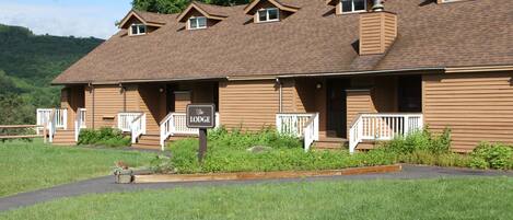 A lodge with a brown exterior, multiple windows, and a sign indicating its name.