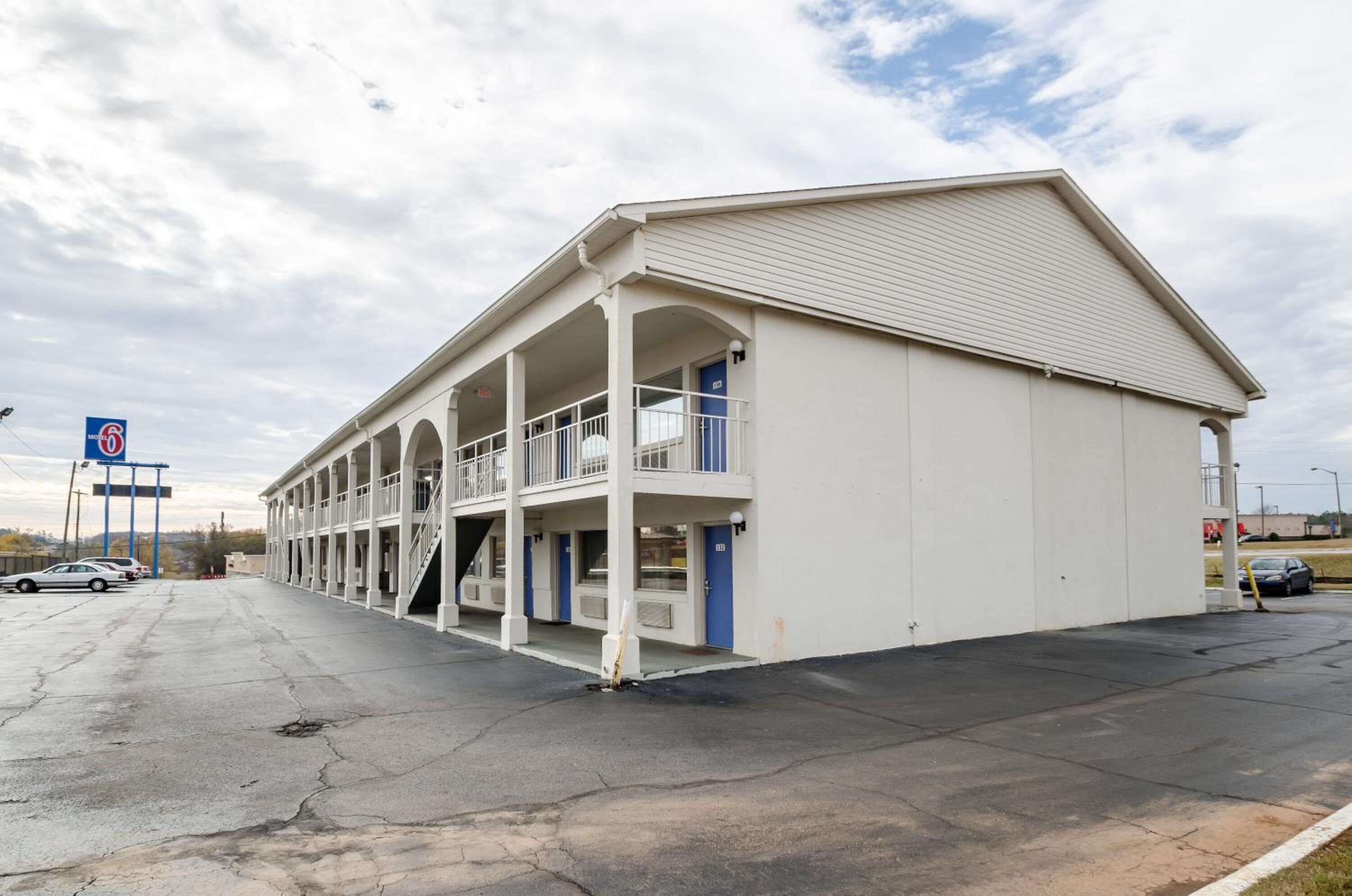 Ein Motel mit einem zentralen Gang, Zimmern beiderseits und einem überdachten Außenbereich.
