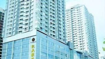 A high-rise building with multiple floors, large windows, and a prominent entrance with signage.
