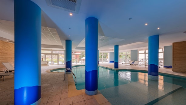 An indoor swimming pool with blue pillars and a tiled floor. - Noemys Les Terrasses de Labrau  (Allos)