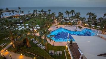 Alberca techada, alberca al aire libre y sombrillas en la alberca