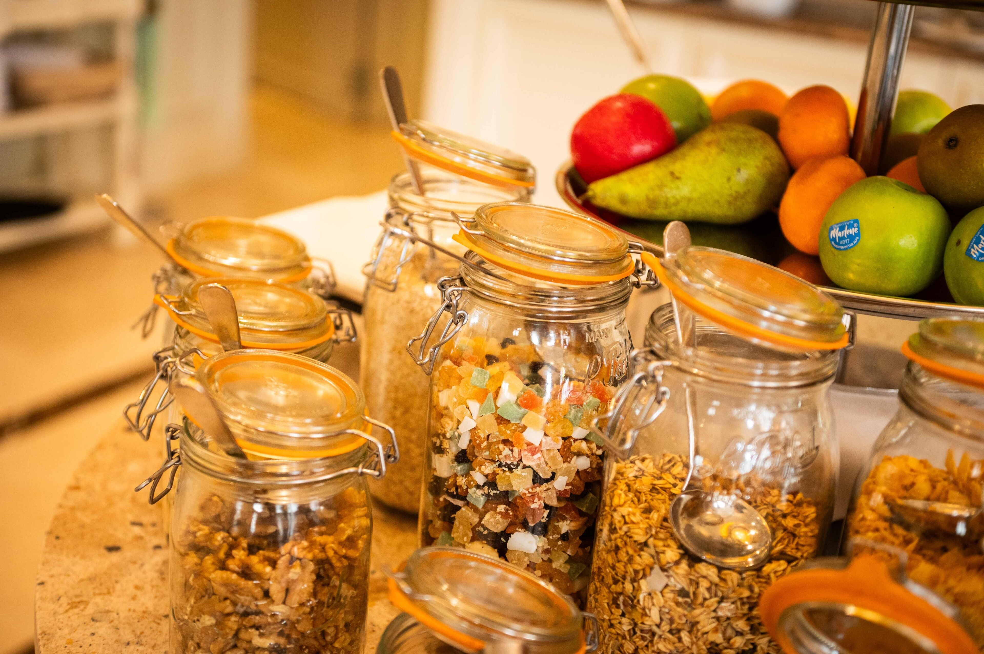 A kitchen counter with various food items and jars.