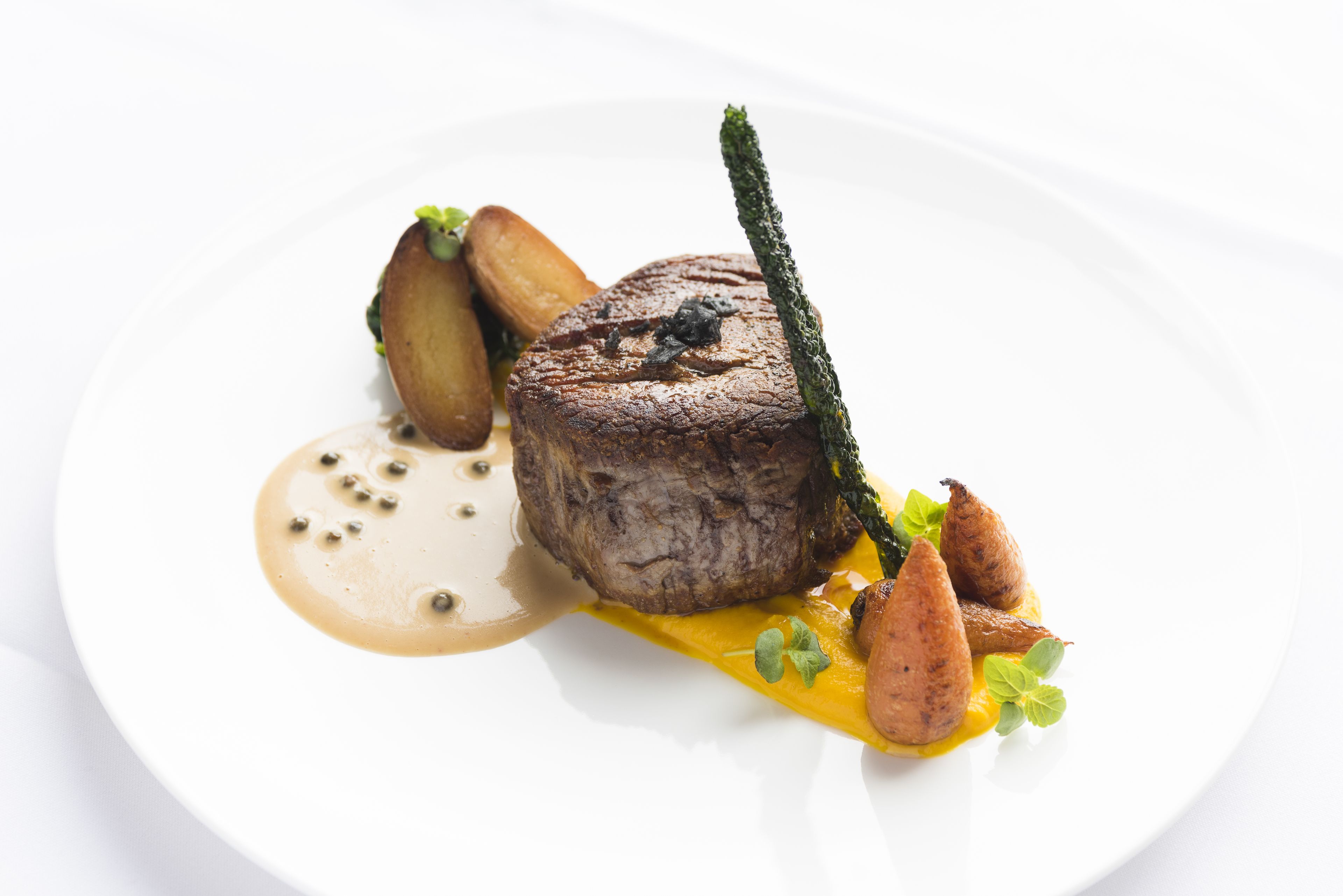 Un plat composé d’un steak, de pommes de terre et de légumes.