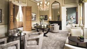 A spacious living room with a chandelier, multiple seating areas, and a fireplace. - Dukes’ Palace – by Dukes’ Hotel Collection (Bruges)