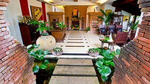 A traditional interior with brick walls, a central staircase, and potted plants. - Muang Samui Spa Resort (Koh Samui)