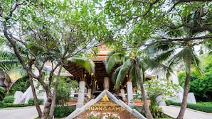 A sign with "MUANGSAMU" and "Orchid" written on it, surrounded by palm trees and a water feature. - Muang Samui Spa Resort (Koh Samui)
