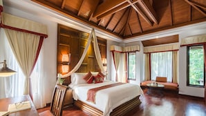 A spacious bedroom with a large bed, a wooden ceiling, and a view of greenery outside. - Muang Samui Spa Resort (Koh Samui)