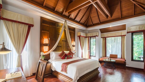A spacious bedroom with a large bed, a wooden ceiling, and a view of greenery outside. - Muang Samui Spa Resort (Koh Samui)