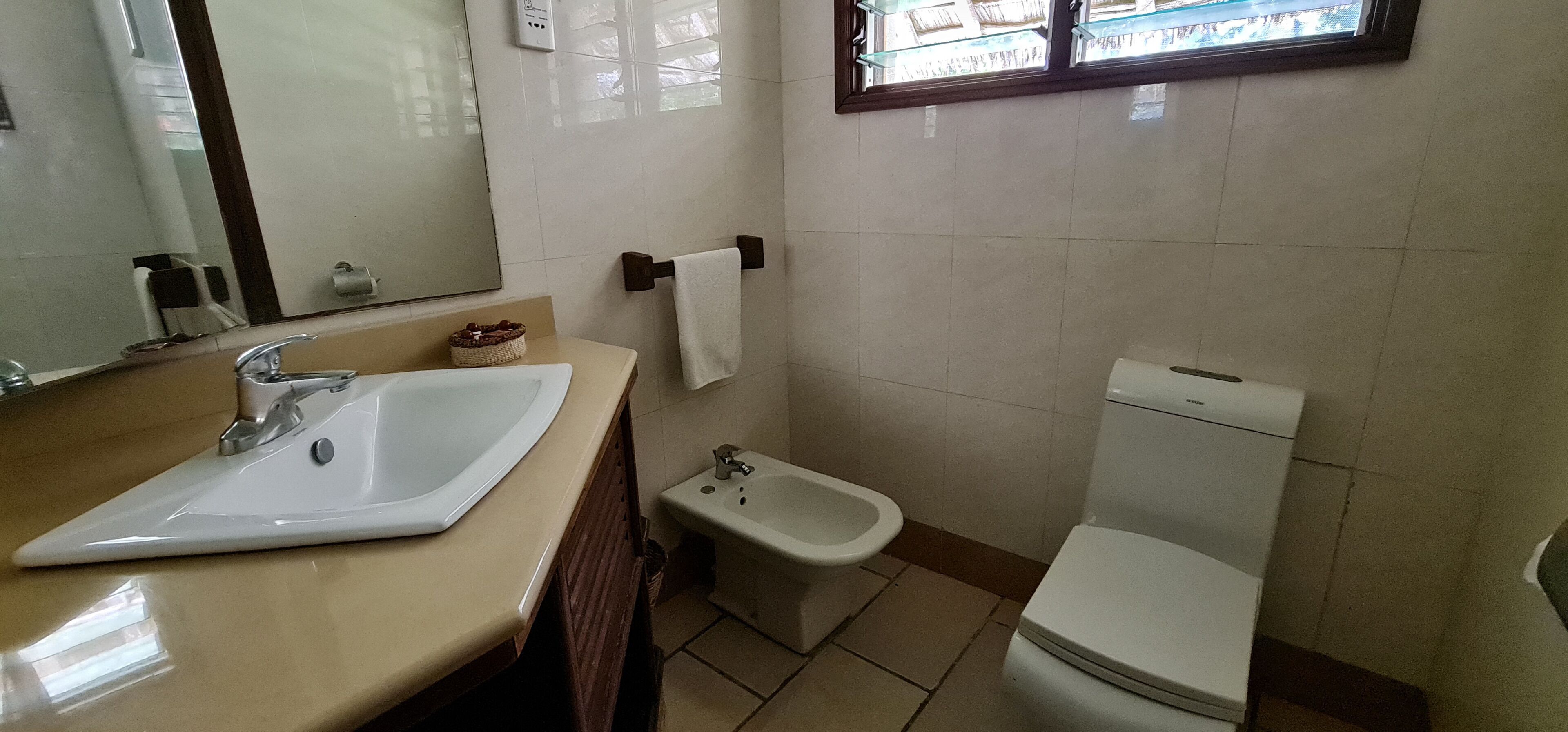 Une salle de bain équipée d’un lavabo, d’un bidet, de toilettes et d’un miroir.