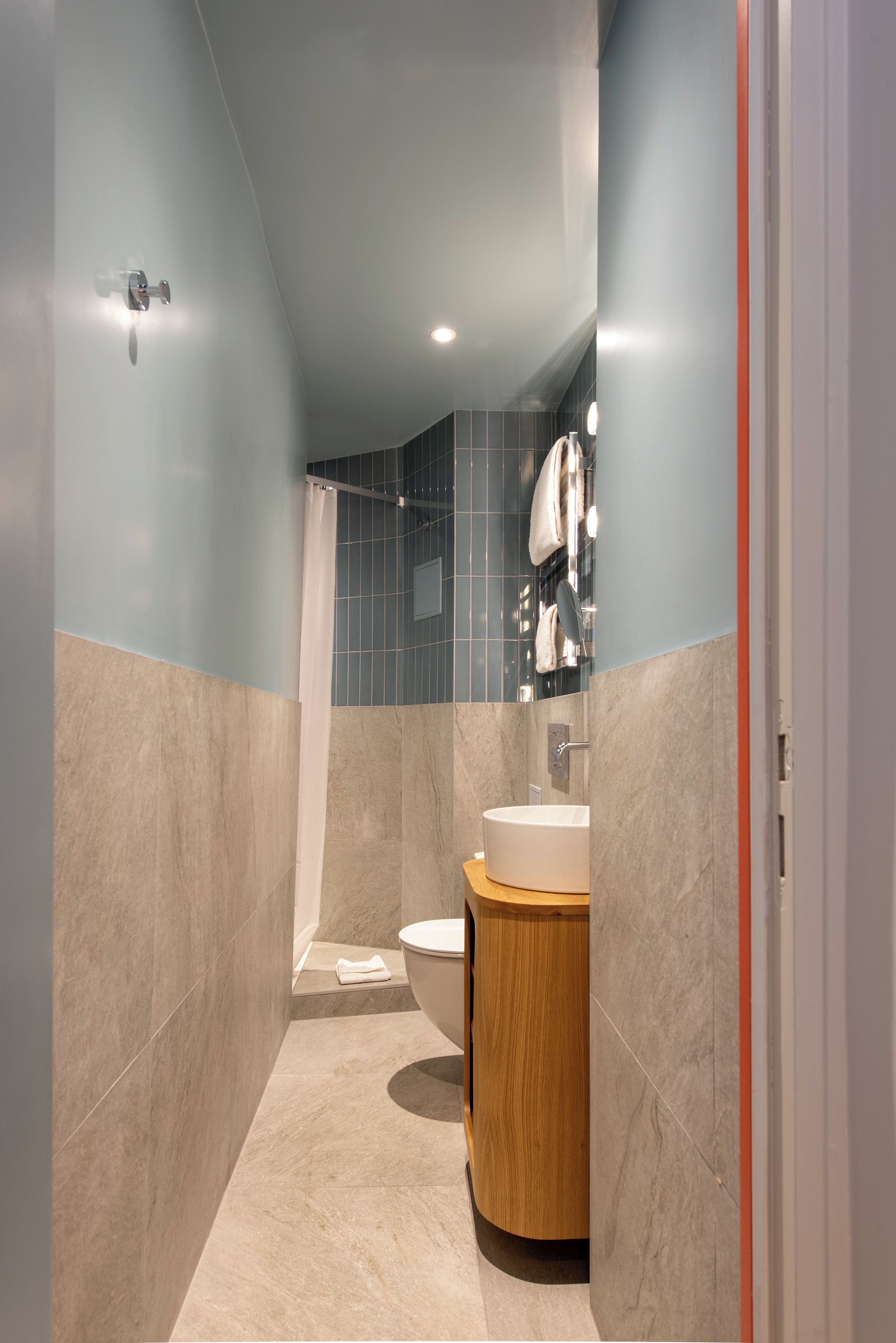 A modern bathroom with a shower, toilet, and sink.