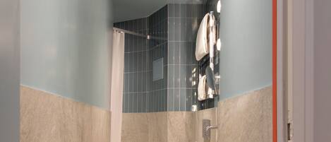 A modern bathroom with a shower, toilet, and sink.
