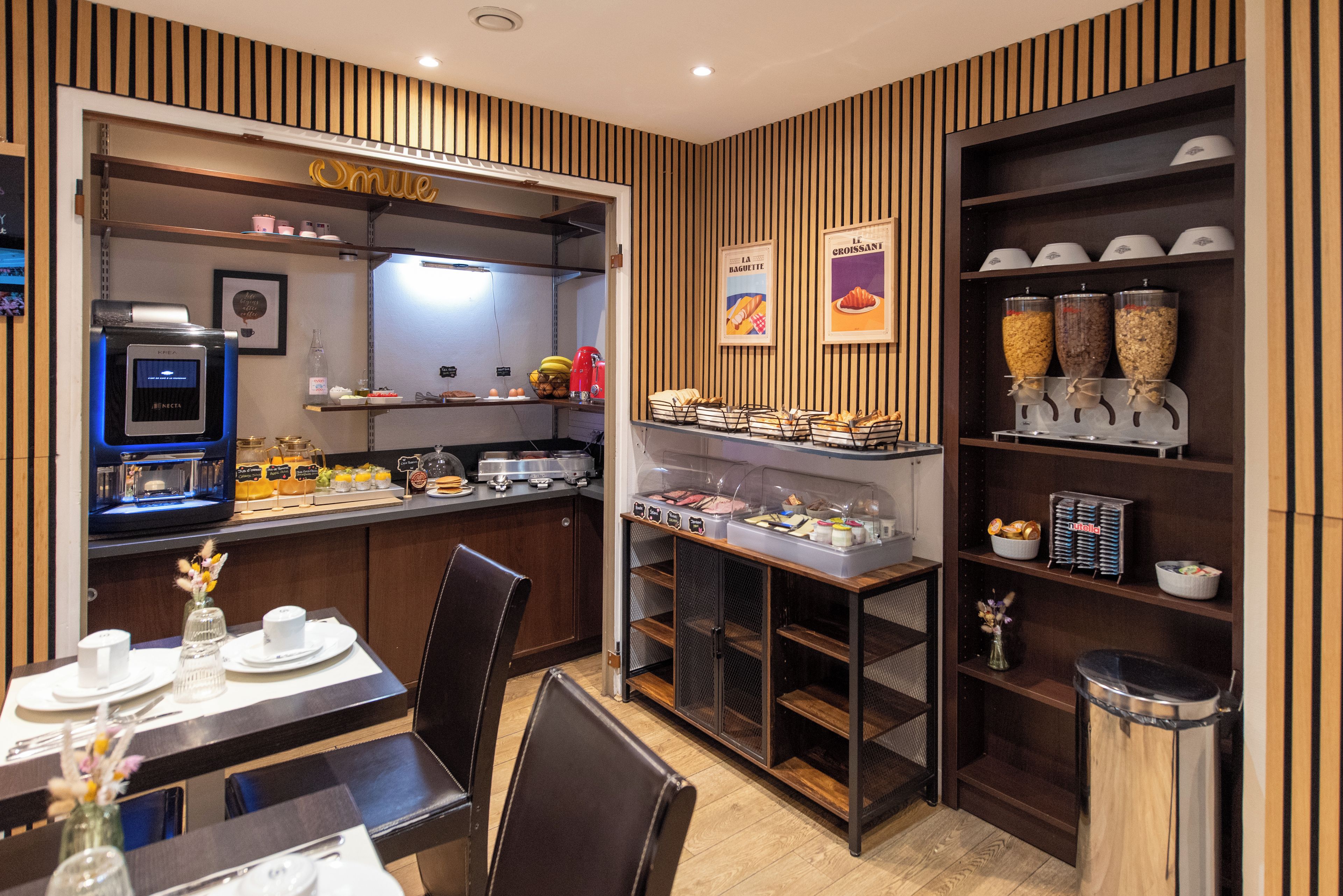 Una sala ristorazione con una colazione a buffet, una macchina da caffè e diversi alimenti esposti sugli scaffali.