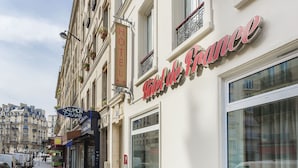 Facciata di un hotel con un grande cartello che riporta "Hotel de France" e un più piccolo cartello per "Sauvignon Caviar".