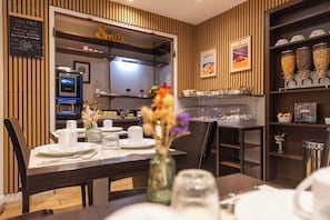 Een restaurantinterieur met een koffieapparaat, een menubord en een presentatie van gerechten.