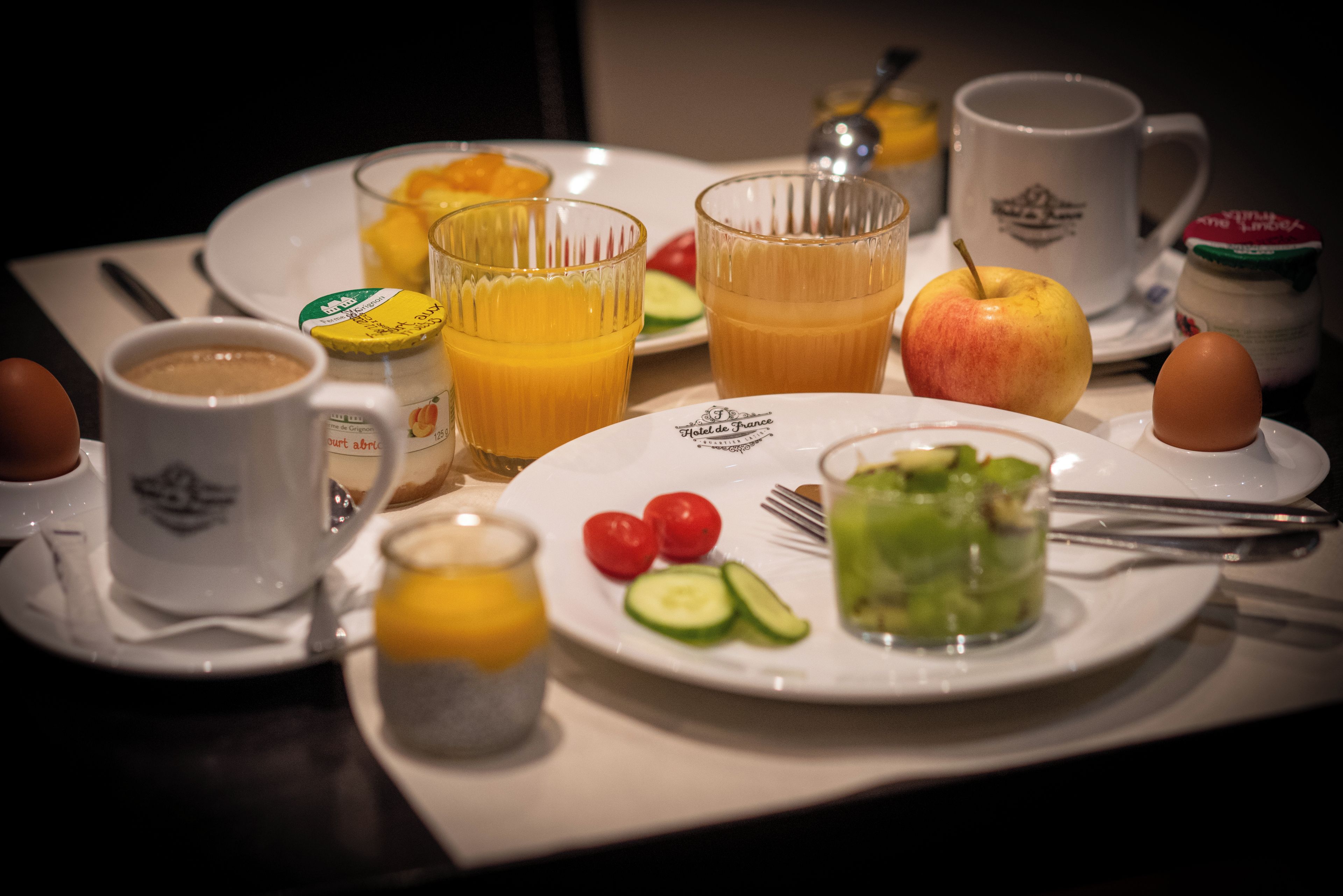 Desayuno con platos, vasos y diversos alimentos.