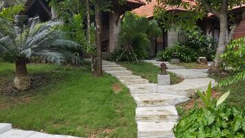 A stone pathway leading to a building with a red-tiled roof.