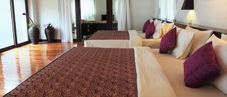 Habitación de hotel con dos camas, un ventanal grande y vistas al exterior.