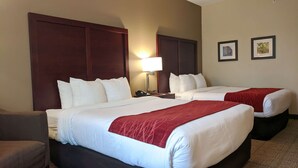 Une chambre d’hôtel avec deux lits, une table de chevet, une lampe et une chaise.