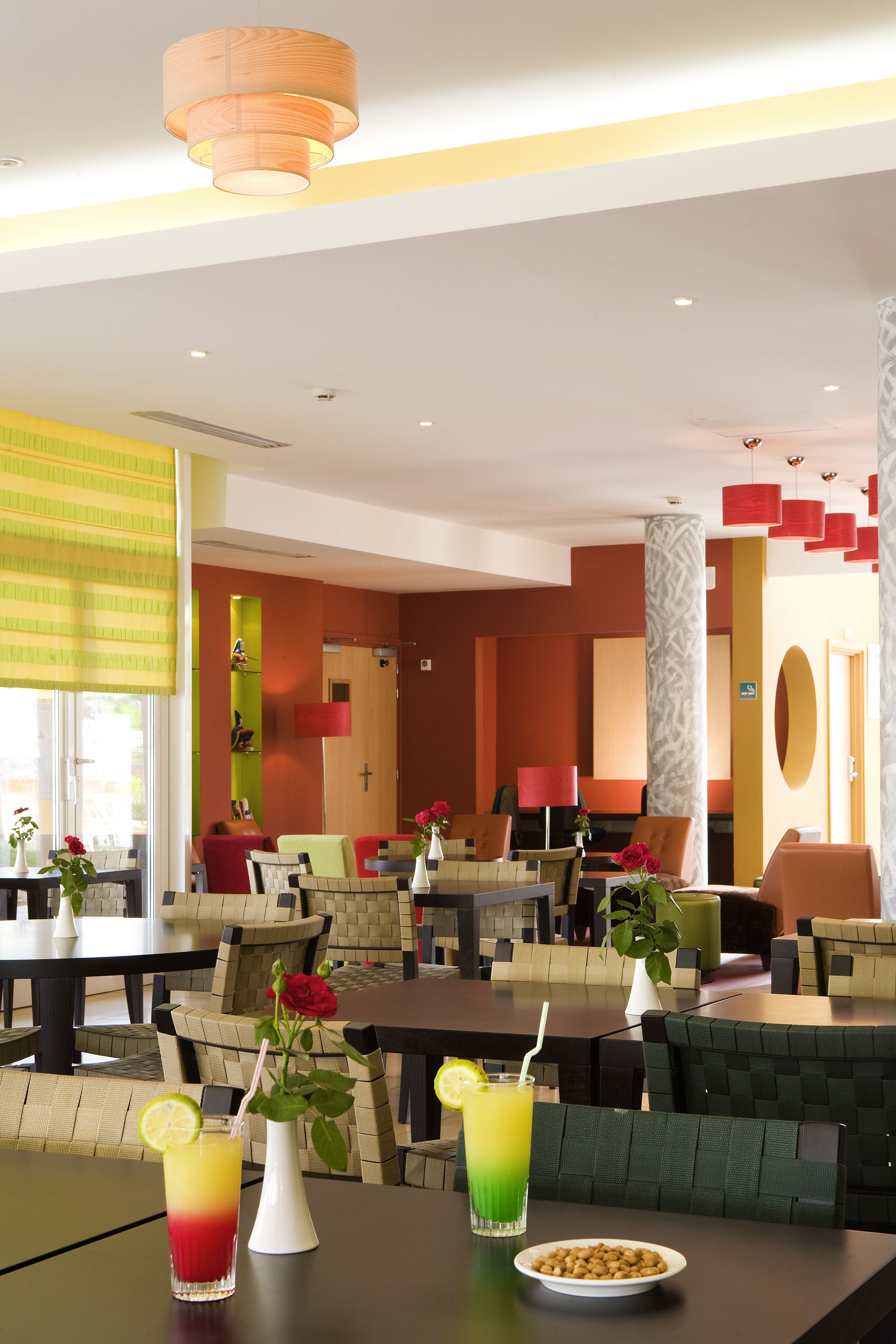 Un moderno vestíbulo de hotel con zonas de estar, una recepción y vistas al exterior.