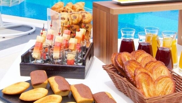 A poolside breakfast setup with pastries, sandwiches, and beverages. - ibis Cotonou (Cotonou)
