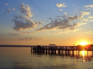 A pier extending into calm waters at sunset with a clear sky. - Romantik Hotel Chalet am Kiental (Herrsching am Ammersee)