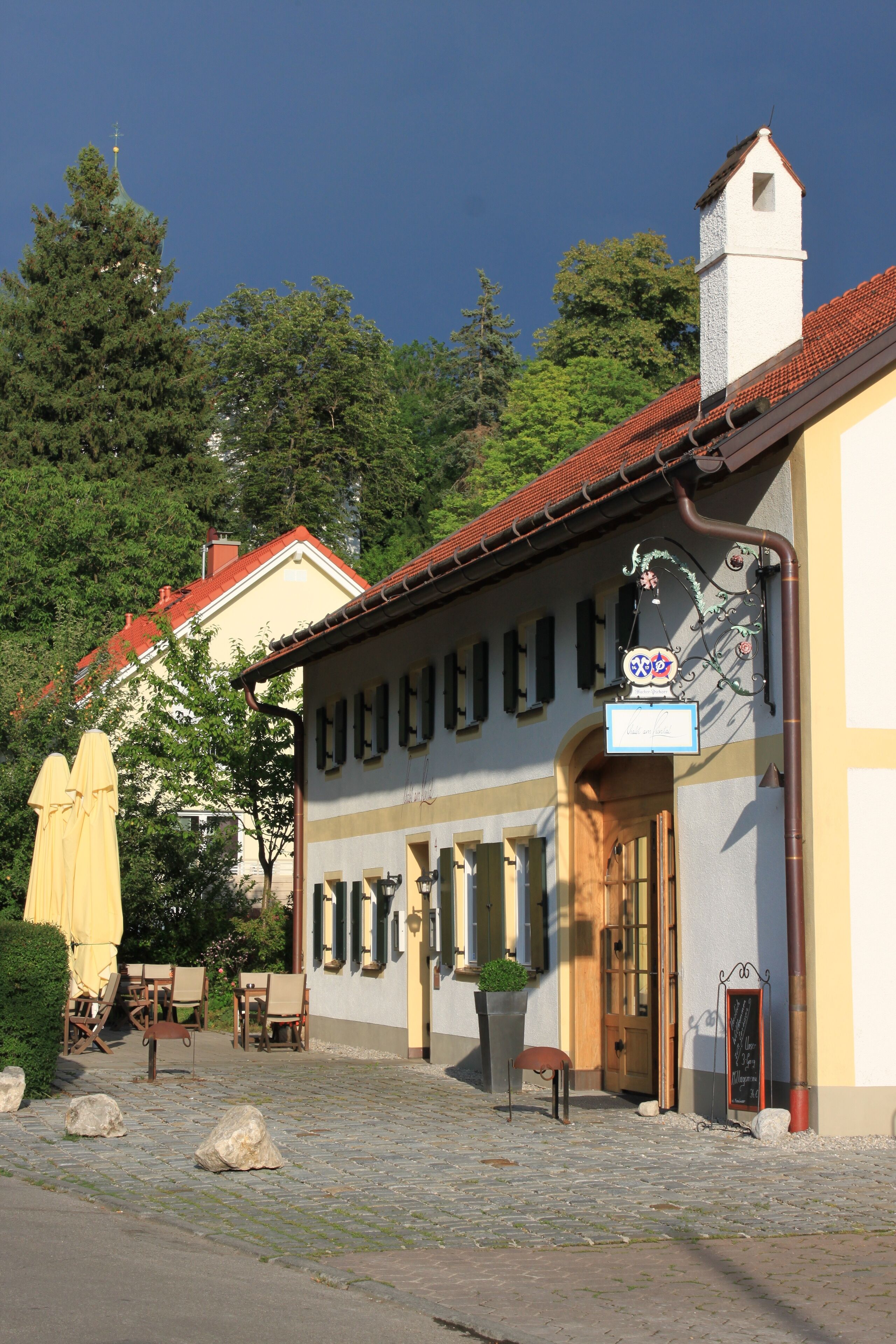 Ein Gebäude im traditionellen Baustil, mit einem markanten Turm und einer Schautafel.