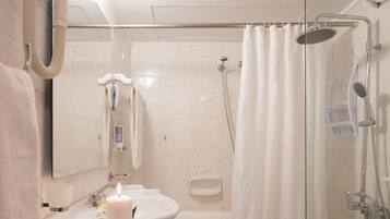 A bathroom with a sink, mirror, and shower.