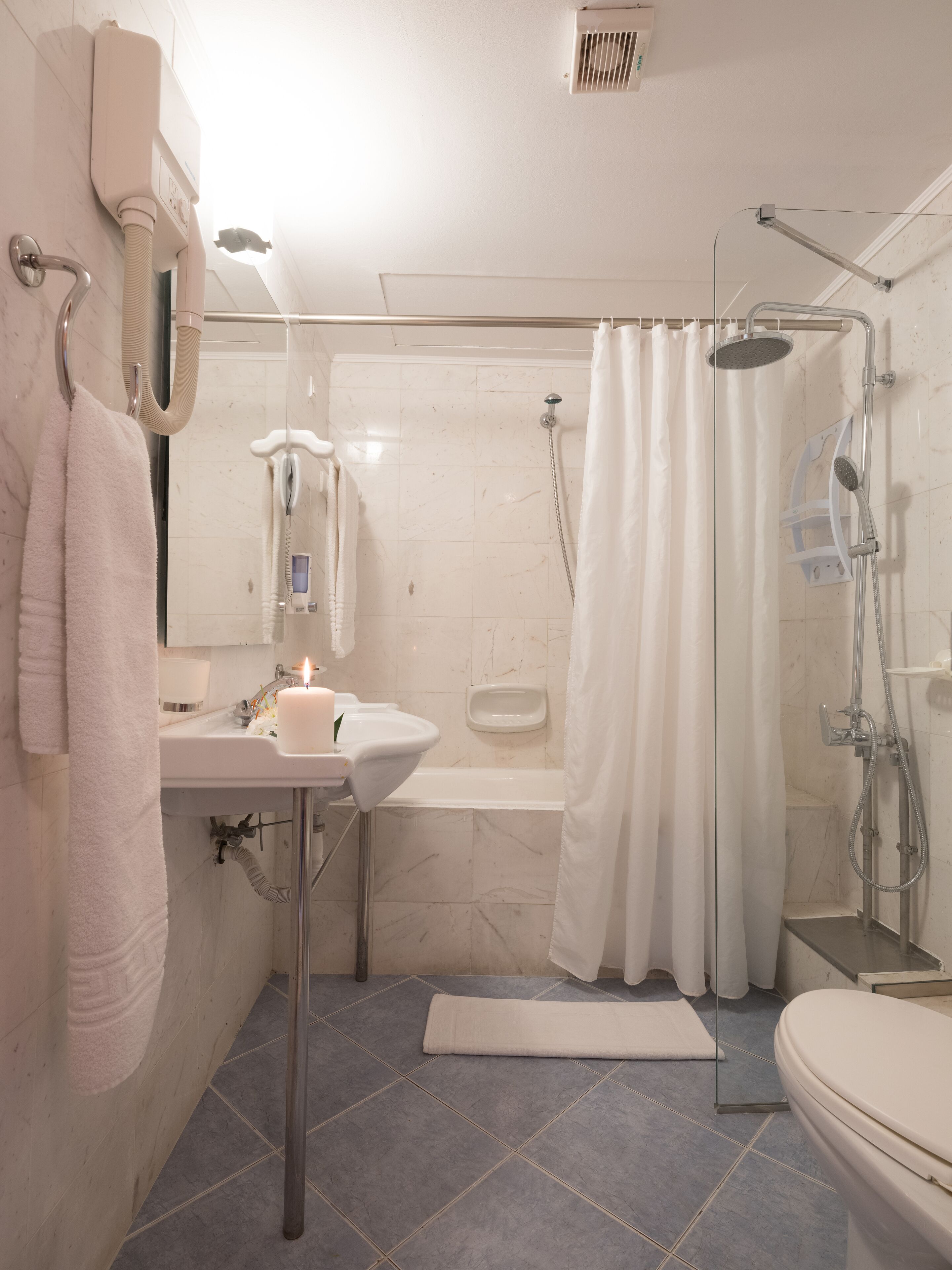 Un baño con lavamanos, espejo y ducha.