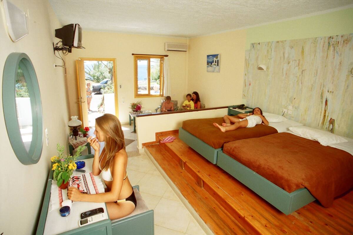Une chambre avec un lit, un bureau et un miroir.