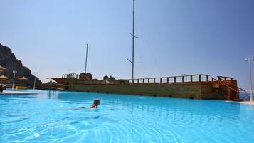A swimming pool with a wooden deck and a lifeguard tower.