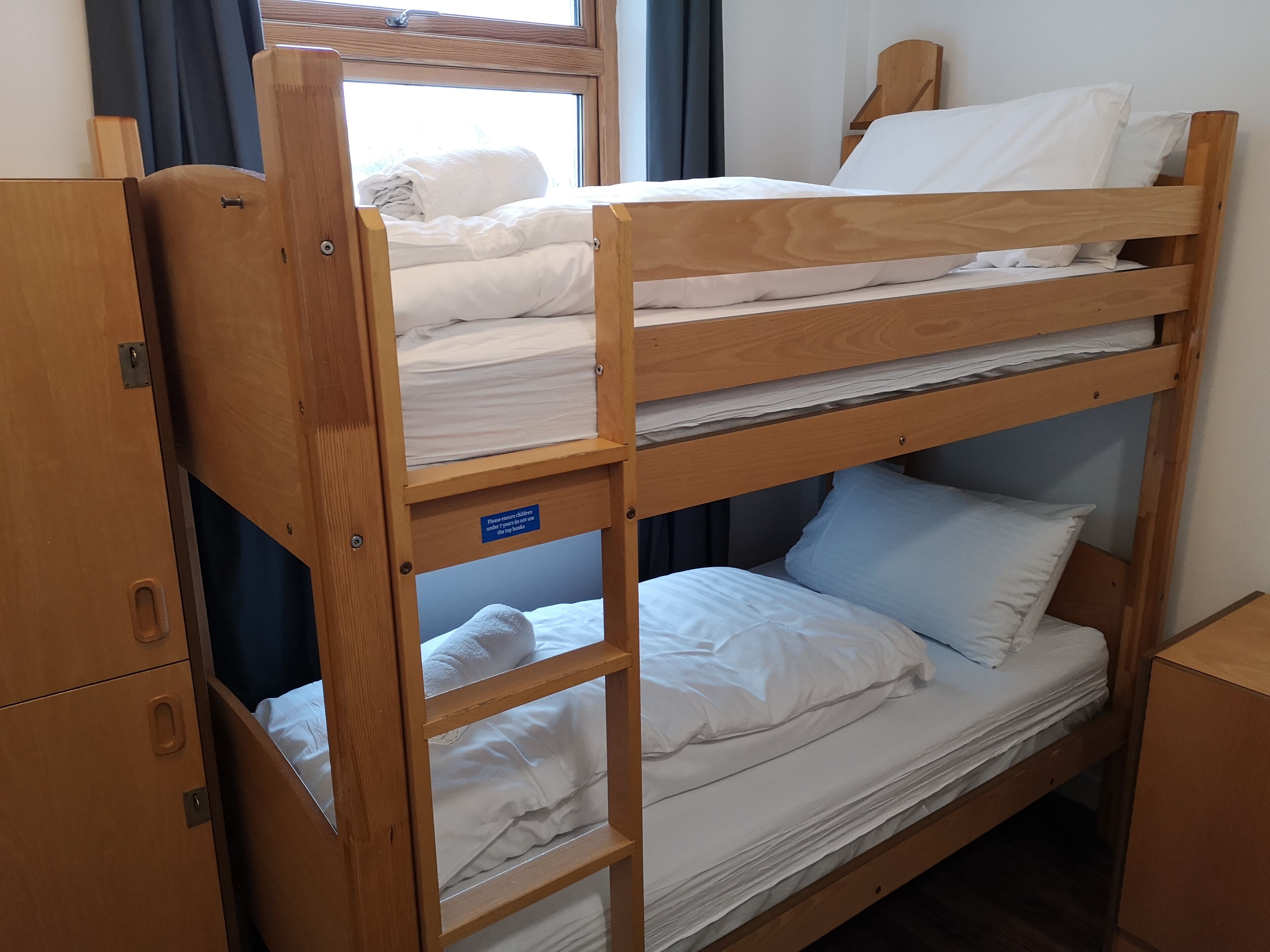 Una cama litera con un cartel que indica que es para niños.