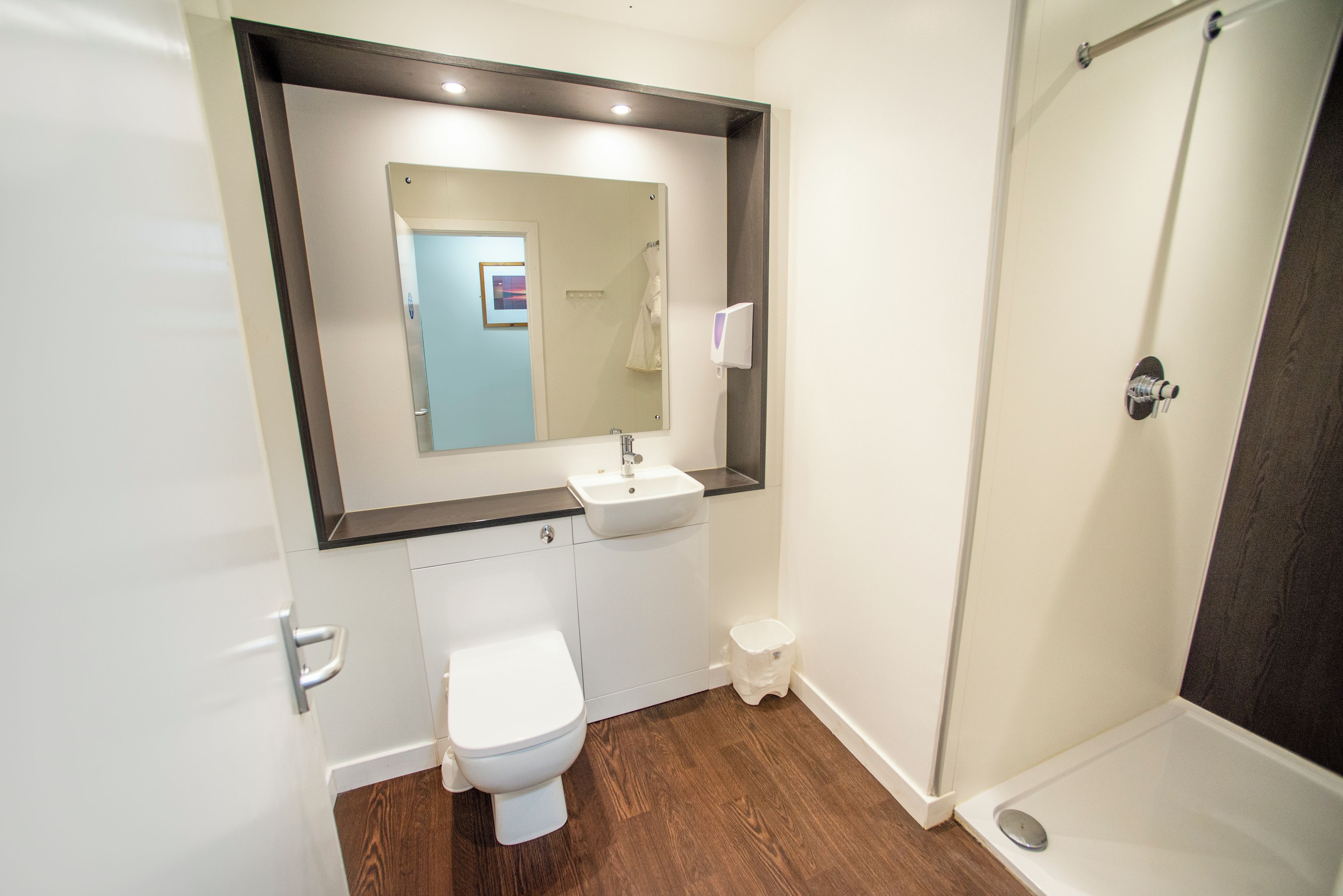 Un baño moderno con inodoro, lavabo y ducha.