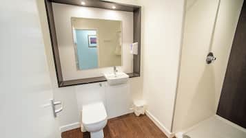 Un baño moderno con inodoro, lavabo y ducha.