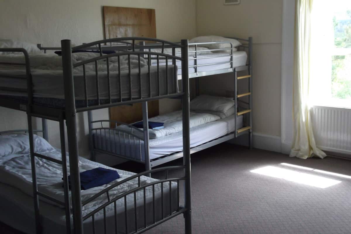 A bunk bed room with a window and a radiator.