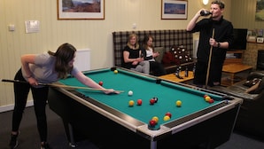 A pool table in a room with a sofa and a television. - Cairngorm Lodge Youth Hostel (Aviemore)