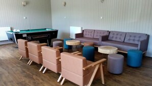 A room with a pool table, a sofa, and multiple chairs. - Cairngorm Lodge Youth Hostel (Aviemore)