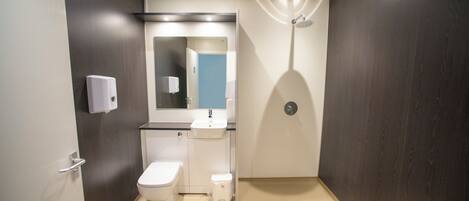 Une salle de bain moderne équipée de toilettes, d’un lavabo et d’une douche.
