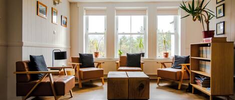 Un salon chaleureux avec une cheminée, des meubles en bois et de grandes fenêtres.
