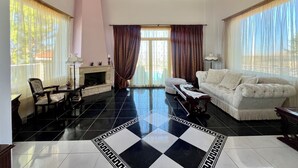 Uma sala de estar ampla com lareira, um sofá e um espaço de jantar.